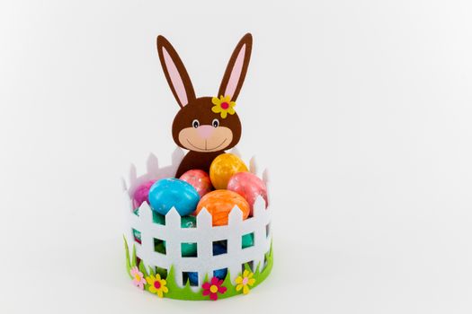 Some Colorful Easter eggs in a basket with an Easter bunny