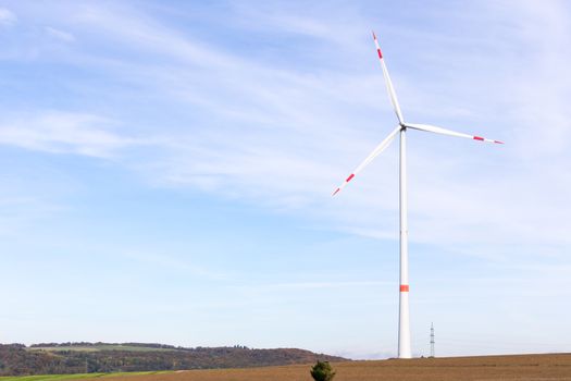 The windmill on a field with blue sky