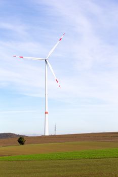 The windmill on a field with blue sky