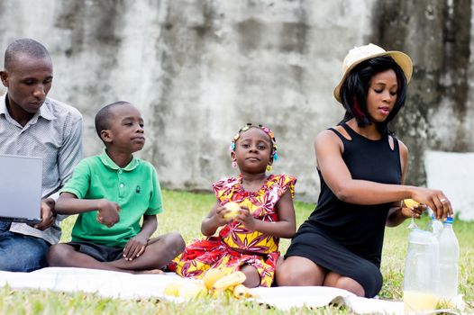 happy family sitting outdoors picnicking and playing together