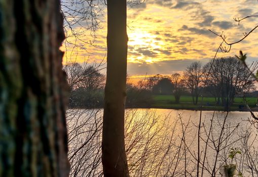 Beautiful sunset landscape at a lake with a reflective water surface.