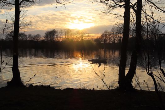 Beautiful sunset landscape at a lake with a reflective water surface.