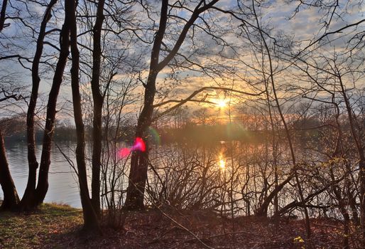 Beautiful sunset landscape at a lake with a reflective water surface.