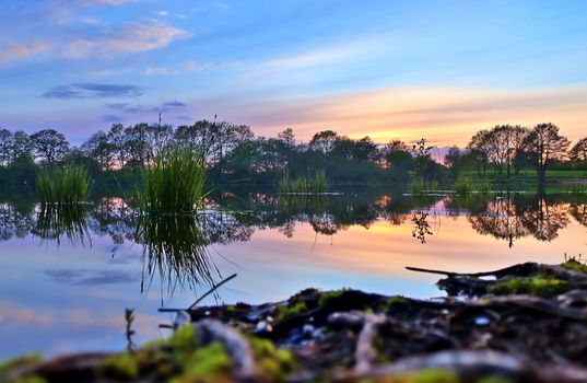 Beautiful sunset landscape at a lake with a reflective water surface.