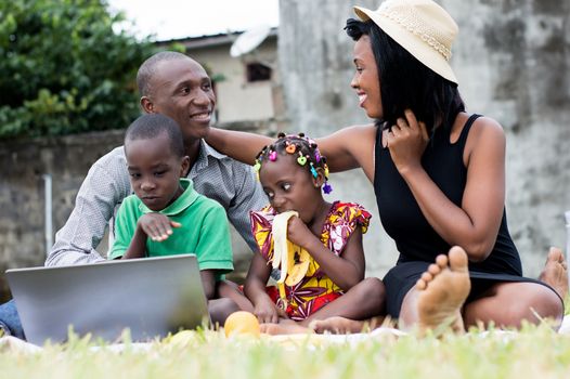 modern and happy family sitting at the park sharing a lunch and playing together