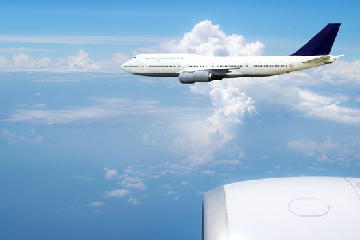 The view from the window of the plane to another plane that was flying in the sky.