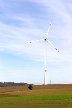 The windmill on a field with blue sky