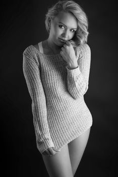 shy young woman in a sweater with long blonde hair