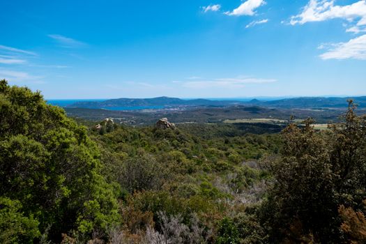 A landscape shot with green forests, mountains and a blue sky