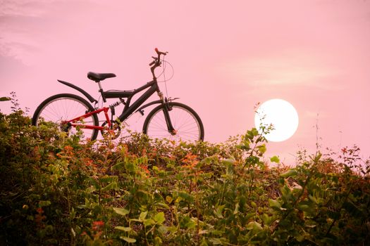 Closeup of the mountain bike with a colorful sky and sunset, vintage tone filter for poster or postcard.