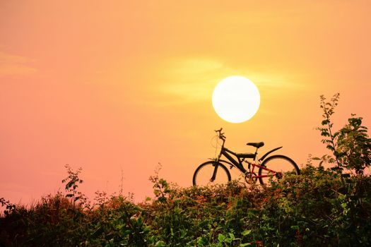 Closeup of the mountain bike with a colorful sky and sunset, vintage tone filter for poster or postcard.