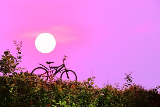 Closeup of the mountain bike with a colorful sky and sunset, vintage tone filter for poster or postcard.