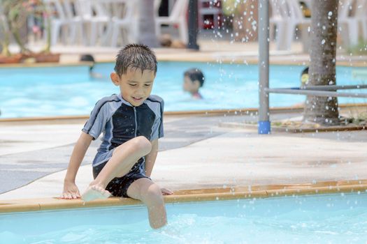 Asian boy in swimwear, swimming fun in the pool.