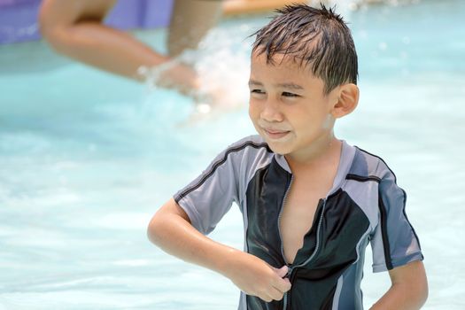 Asian boy in swimwear, swimming fun in the pool.