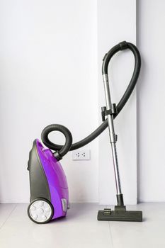 Colorful of electric vacuum cleaner in the white room.