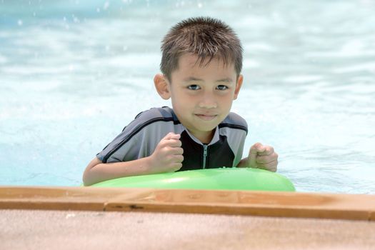 Asian boy in swimwear, swimming fun in the pool.