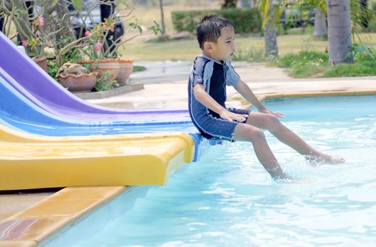 Asian boy in swimwear, swimming fun in the pool.