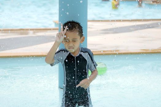 Asian boy in swimwear, swimming fun in the pool.