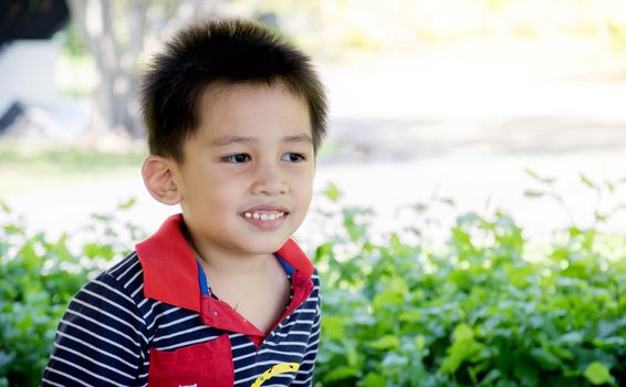 Closeup of the face of Asian boy smiling happily.