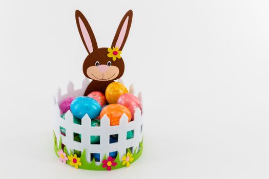 Some Colorful Easter eggs in a basket with an Easter bunny