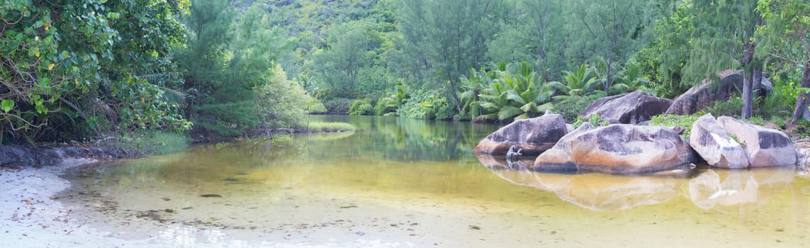 Big stones on the beach of the Seychelles and clear water