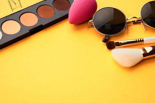 Professional eyeshadows and makeup brushes on a yellow background make-up decoration. High quality photo