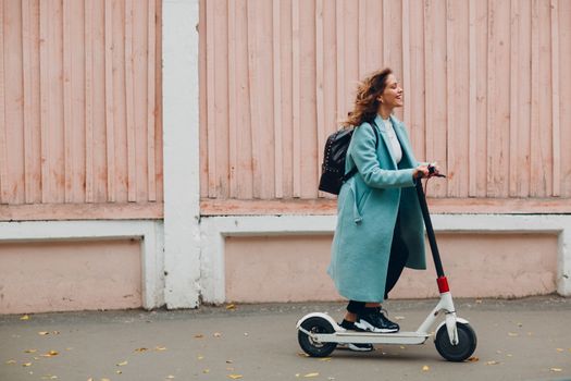 Young woman with electric scooter at the city.