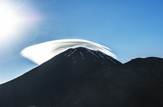 Mount Ngauruhoe with a cloud cap in a morning sun. It is a famous stratovolcano in a Tongariro national park, New Zealand