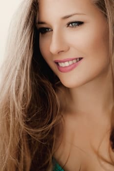 Elegant woman smiling, brunette with long light brown hair, girl wearing natural makeup look, female showing healthy white teeth, beauty portrait for cosmetic or lifestyle brands