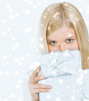 Merry Christmas and glitter snow background, happy blonde girl with gift boxes in winter season for shopping sale and holiday brands