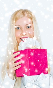 Magical Christmas and glitter snow background, happy blonde girl with gift boxes in winter season for shopping sale and holiday brands