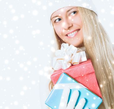 Happy Christmas and glitter snow background, happy blonde girl with gift boxes in winter season for shopping sale and holiday brands