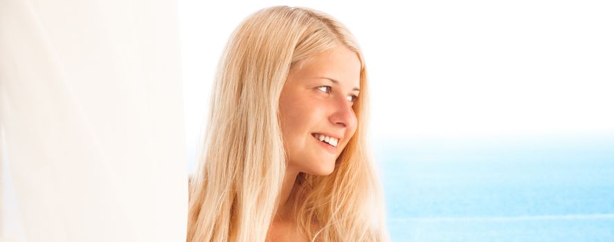 Woman with blond hair enjoying seaside and beach lifestyle in summertime, holiday travel and leisure concept