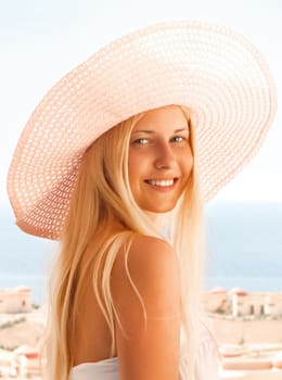 Woman with blond hair wearing hat, enjoying seaside and beach lifestyle in summertime, holiday travel and leisure concept