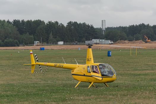 Minsk, Belarus - 07/25/2018: Helicopter on the green lawn of the airfield. Stock photo.