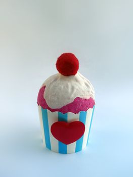Cupcake pink whipped cream decorated with red heart and ball red on white background. Muffin blue e white stripe decoration line. sweet food