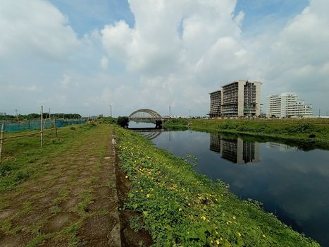 stylish steel and concrete bridge on lake with apartment with nature