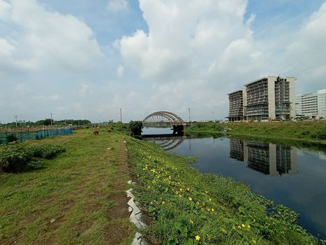 stylish steel and concrete bridge on lake with apartment with nature