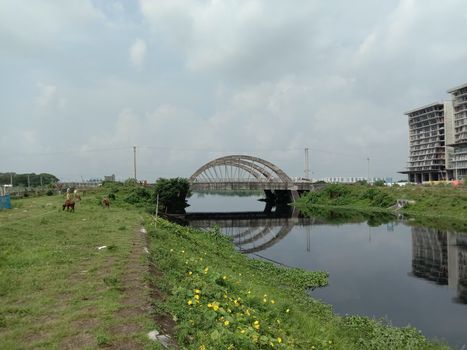 stylish steel and concrete bridge on lake with nature