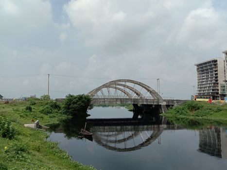 stylish steel and concrete bridge on lake with nature