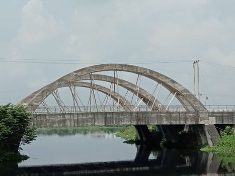 stylish steel and concrete bridge on lake with nature