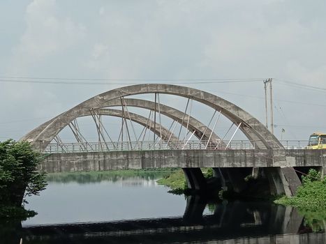 stylish steel and concrete bridge on lake with nature