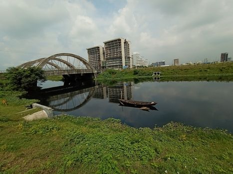 stylish steel and concrete bridge on lake with apartment with nature