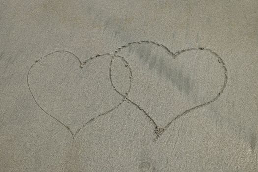 valentines, two hearts on the beach. two hearts drawn on perfectly white sand of paradise beach.