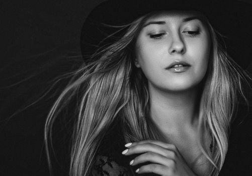 Beautiful blonde woman wearing a hat, artistic film portrait in black and white for fashion campaign and beauty brands