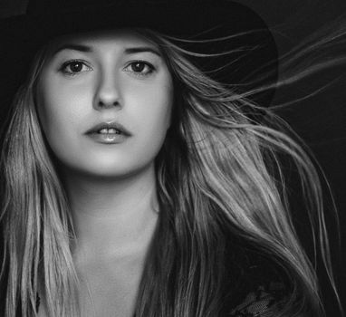 Beautiful blonde woman wearing a hat, artistic film portrait in black and white for fashion campaign and beauty brands