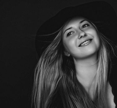 Beautiful blonde woman wearing a hat, artistic film portrait in black and white for fashion campaign and beauty brands