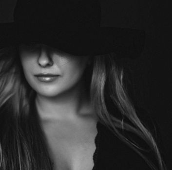 Beautiful blonde woman wearing a hat, artistic film portrait in black and white for fashion campaign and beauty brands