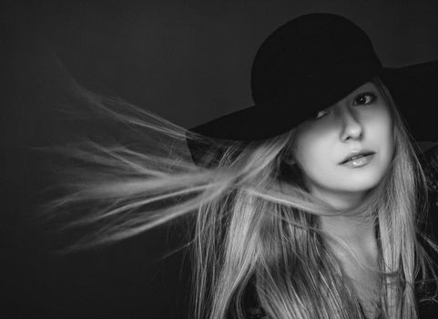 Beautiful blonde woman wearing a hat, artistic film portrait in black and white for fashion campaign and beauty brands