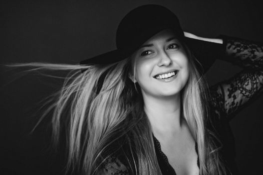 Beautiful blonde woman wearing a hat, artistic film portrait in black and white for fashion campaign and beauty brands